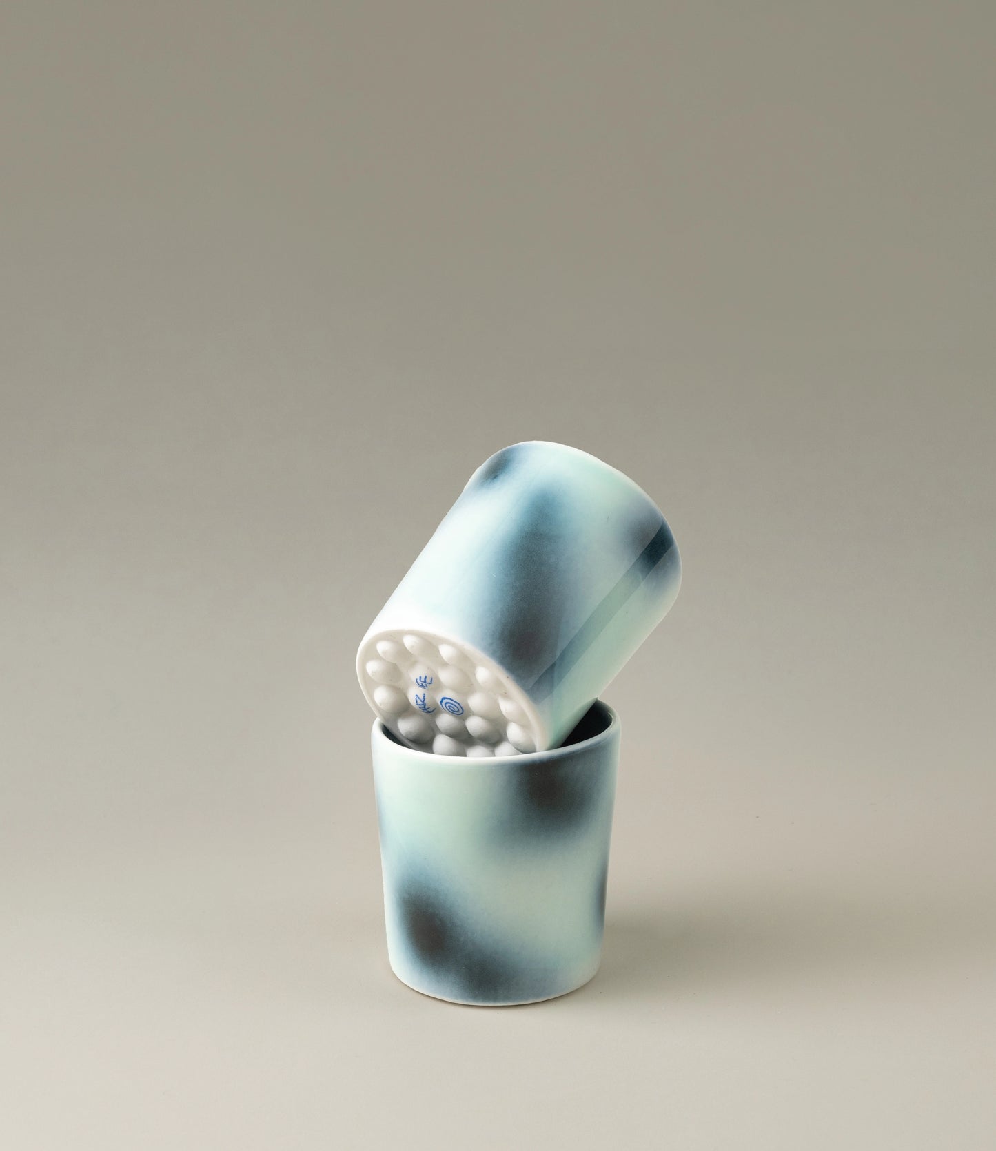 Bulle Cup from Frizbee Ceramics has a unique gradient painted pattern. The product which comes in a set of two, has cold colors like green, dark and light blue. The bottom of the cup looks like it's made of small bubbles.